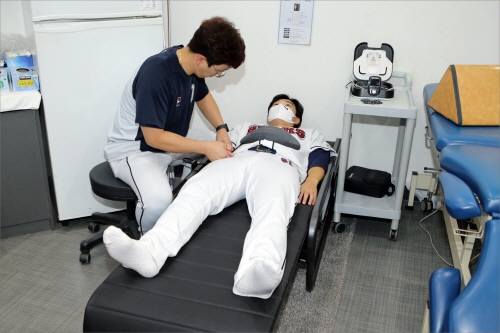 두산 베어스 최원준 선수가 세라젬 척추 의료가전을 사용하고 있는 모습.